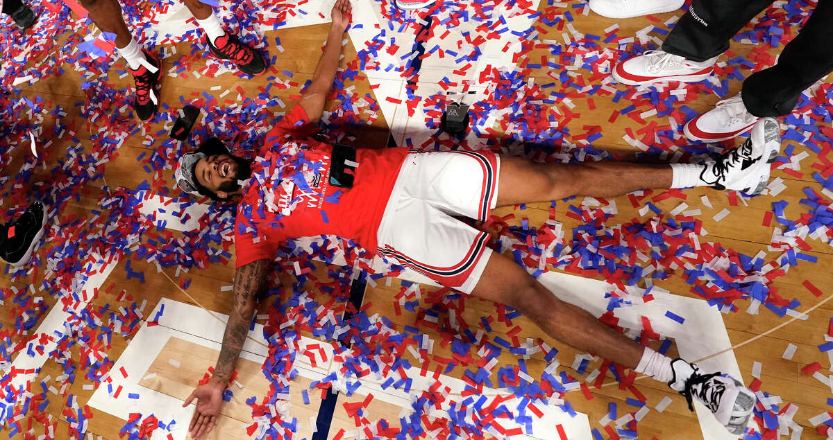 Houston guard Kyler Edwards celebrates on the floor after his team defeated Memphis to win an NCAA college basketball game against Memphis for the American Athletic Conference tournament championship in Fort Worth, Texas, Sunday, March 13, 2022. (AP Photo/LM Otero)