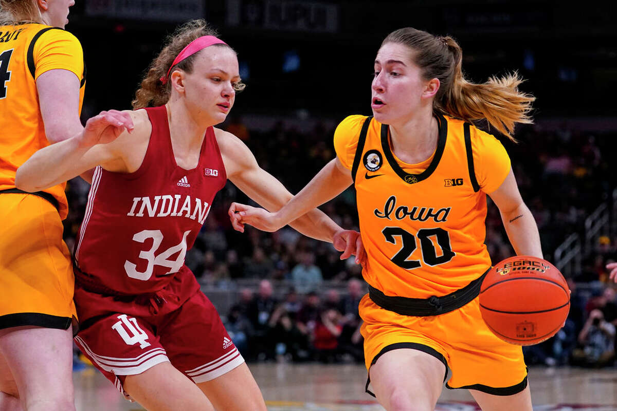 Iowa guard Kate Martin (20) drives on Indiana guard Grace Berger (34) in the first half of an NCAA college basketball game for the championship of the Big Ten Conference tournament in Indianapolis, Sunday, March 6, 2022.