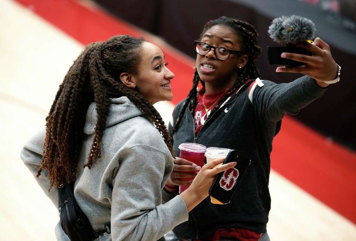 Stanford guard Haley Jones (30) and Stanford forward Francesca Belibi (5) reacts to the selection by taking a video selfie after theS tanford’s women's placement as a No. 2 seed play Montana State #16 seed while watching the women's NCAA college basketball tournament selection show at Maples Pavilion in Stanford, Calif., on March 13, 2022.