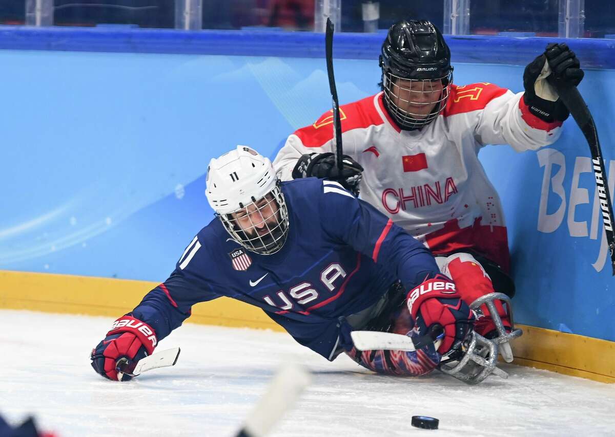 Shen Yifeng R of China vies with Port Hope's Joey Woodke of the United States during the Para Ice Hockey semifinals match between China and the United States of the Beijing 2022 Paralympic Winter Games in Beijing on Sunday.  