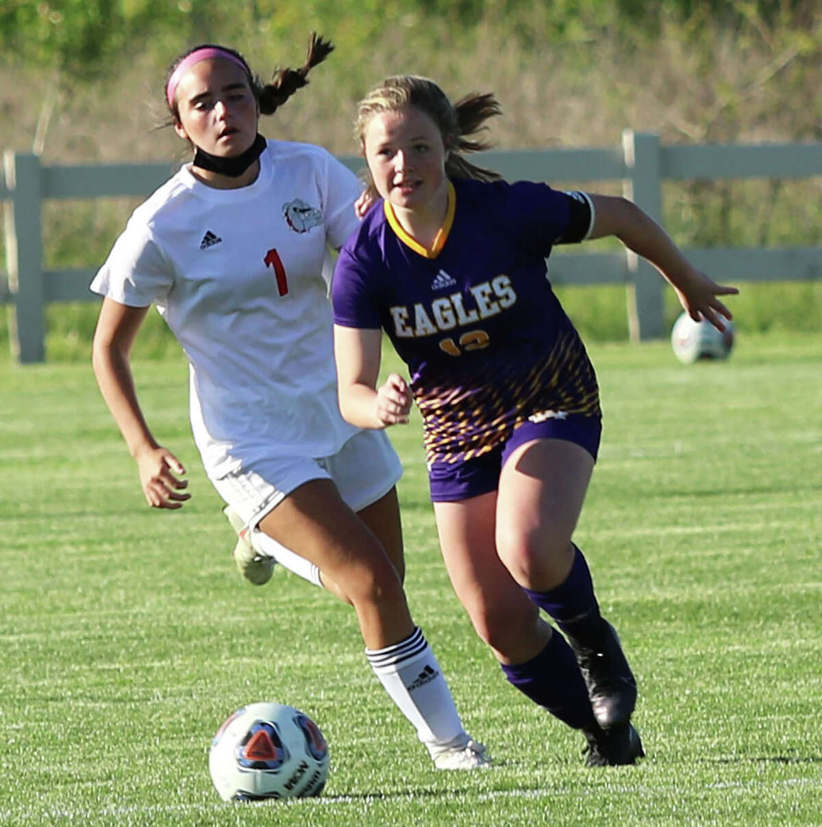 CM's Aubree Wallace (right) pushes the ball ahead of Highland's Brooke Hunsche during a MVC game last season at the Bethalto Sports Complex. Wallace who had three goals in this win and 23 for the season, will miss the 2022 season with a knee injury.
