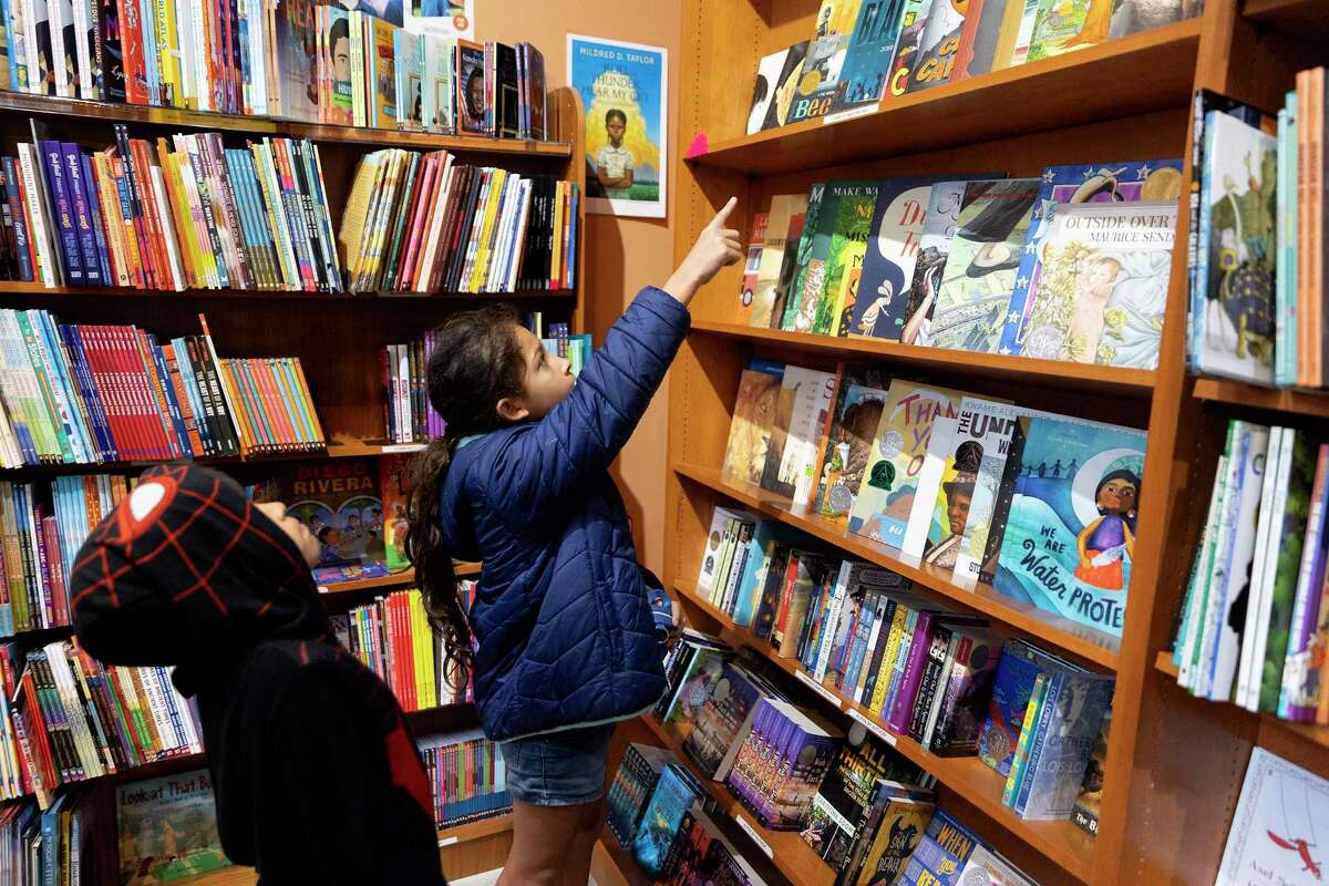 Sabrina Castanon points out a book for her younger brother Orion at the Twig Bookstore.