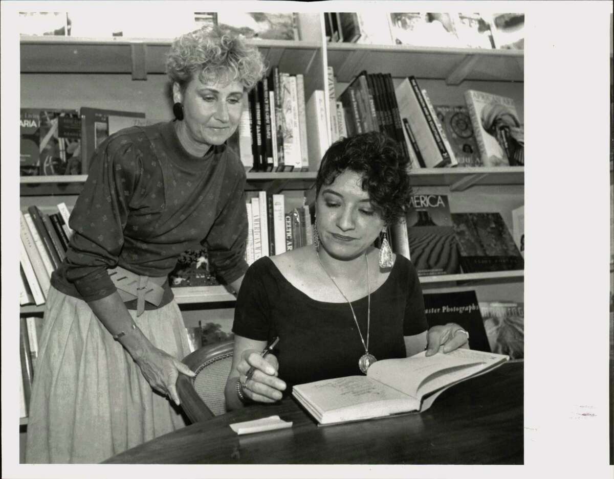 In this 1991 photo, author Sandra Cisneros signs a copy of her book, 