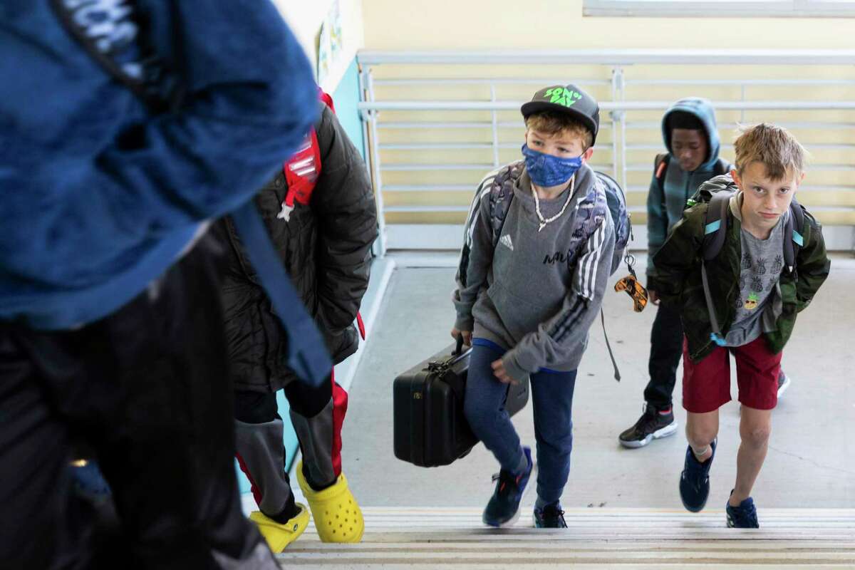 Students arrive at Ruth Acty Elementary School in Berkeley, Calif. on March 14, 2022, some with masks and others without.
