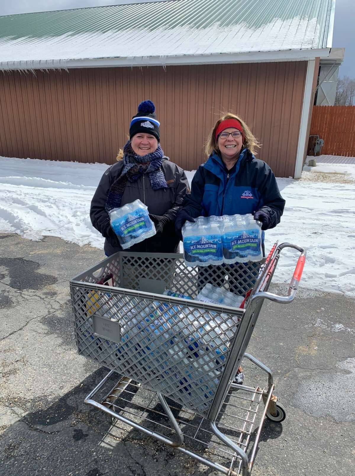 Ice Mountain employees Mary Emerson and Kathy Pratt help distribute food and water during the Barryton Mobile Food Pantry distribution March 12. The organization handed out food to 130 families.