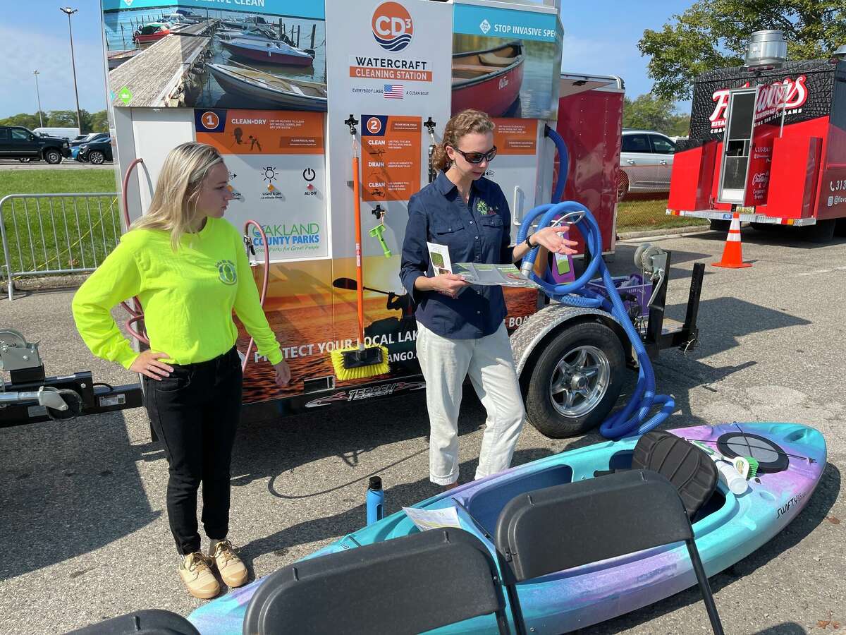 Cleaning off your boat after moving from one body of water to another is the law. Pictured is Oakland County and Lake St. Clair CISMA staff giving a demonstration with an Oakland County Board of Commissioners-funded mobile boat-cleaning station.