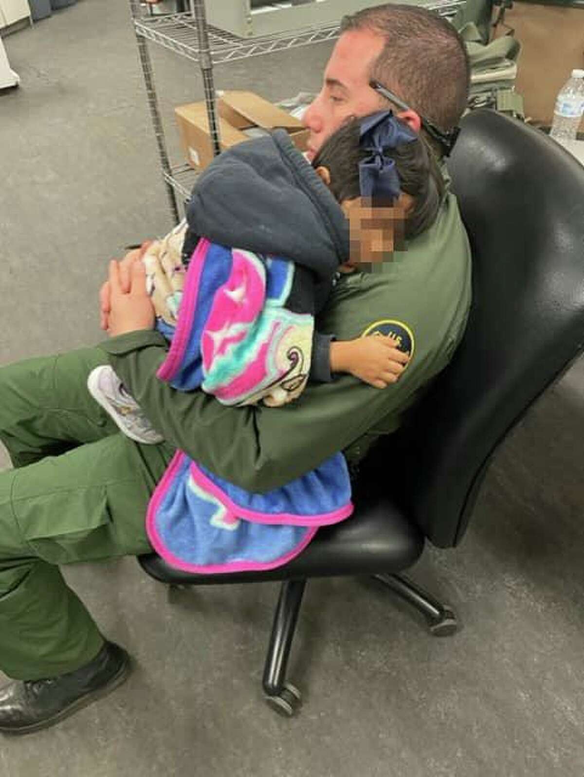 A U.S. Border Patrol Laredo Station agent is pictured with a young child after she was discovered at the Interstate 35 checkpoint without her parents on March 8, 2022.