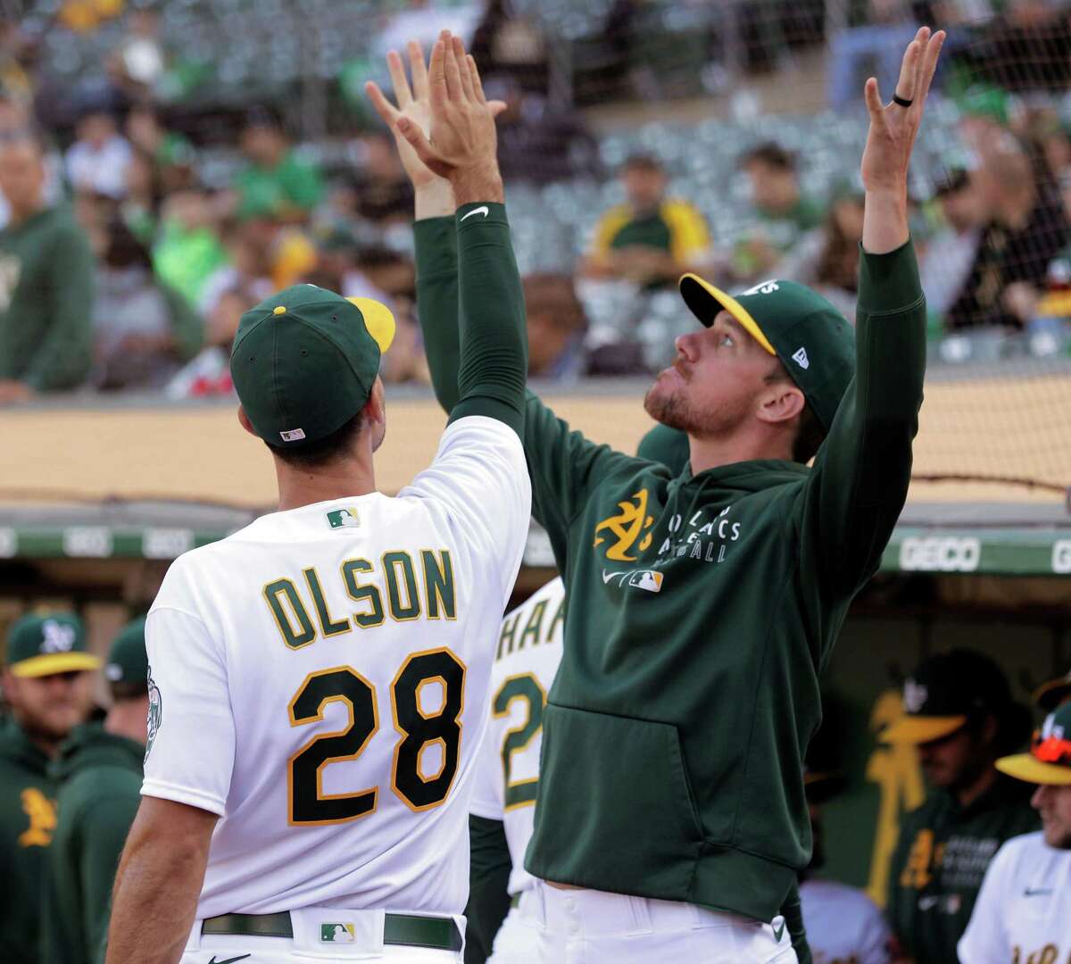 Matt Olson (28) and Chris Bassitt (40) gesture in the dugout before the Oakland Athletics played the Texas Rangers at the Coliseum in Oakland, Calif., on Tuesday, June 29, 2021.