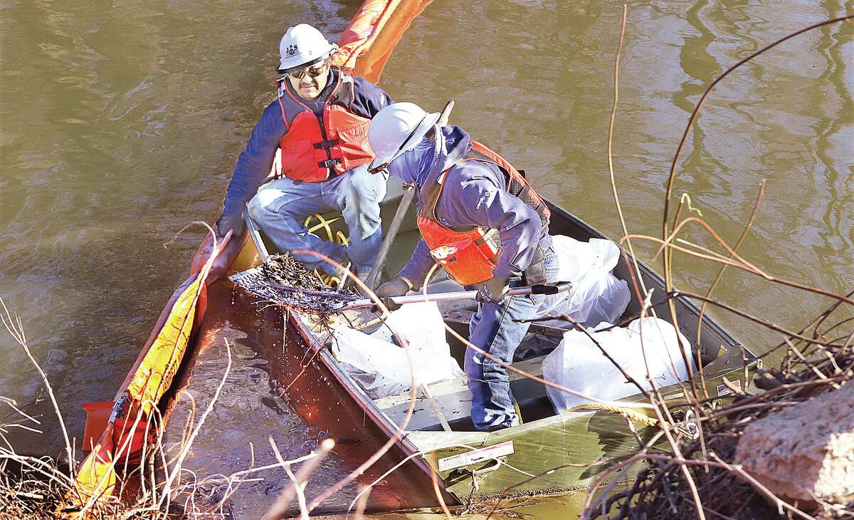 John Badman|The Telegraph Workers remove plant debris out of the Hartford Spillway Monday looking for crude oil contamination following Friday's Marathon pipeline leak near Illinois 143 and 159.