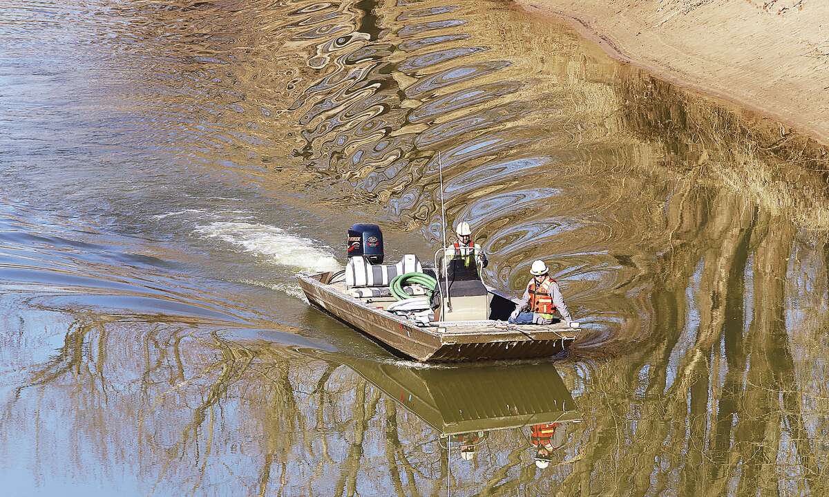 A boat from an environmental cleanup company patrols the Cahokia Diversion Canal under Illinois Route 255 Monday following Friday's pipeline leak of an estimated 247,799 gallons of a "crude oil and water" mix which spilled into the canal near Illinois Routes 143 and 159 in Edwardsville. Oil absorbing booms have been stretched in several places across the canal from Edwardsville all the may to near where the canal spills into the Mississippi River in Hartford. Wanda Road was closed near the Edwardsville Waste Water Treatment Plant where a massive cleanup operation was underway in the canal. Boats, heavy equipment, and vaccum trucks crowded the road where the operation was apparently working day and night with portable light systems.