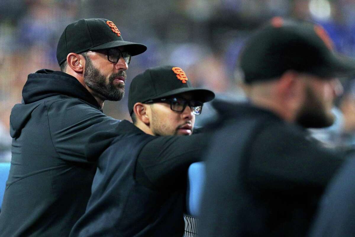 San Francisco Giants manager Gabe Kapler, left, and bench/infield coach Kai Correa watch the game from the dugout as the San Francisco Giants played the Los Angeles Dodgers in Game 4 of the National League Division Series at Dodger Stadium in Los Angeles, Calif., on Tuesday, Oct. 12, 2021.