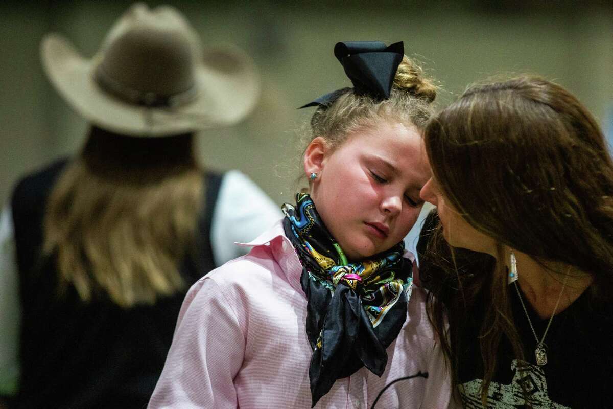 Renee Gober talks to her daughter Izzy Gober, 9, as Izzy parts ways with her pig Spotty after competition in the Houston Livestock Show and Rodeo, Monday, March 14, 2022, in Houston.