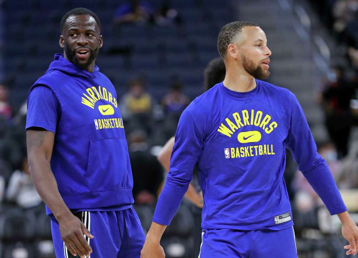 Draymond Green (left) and Stephen Curry of the Warriors warm up before Monday’s game.