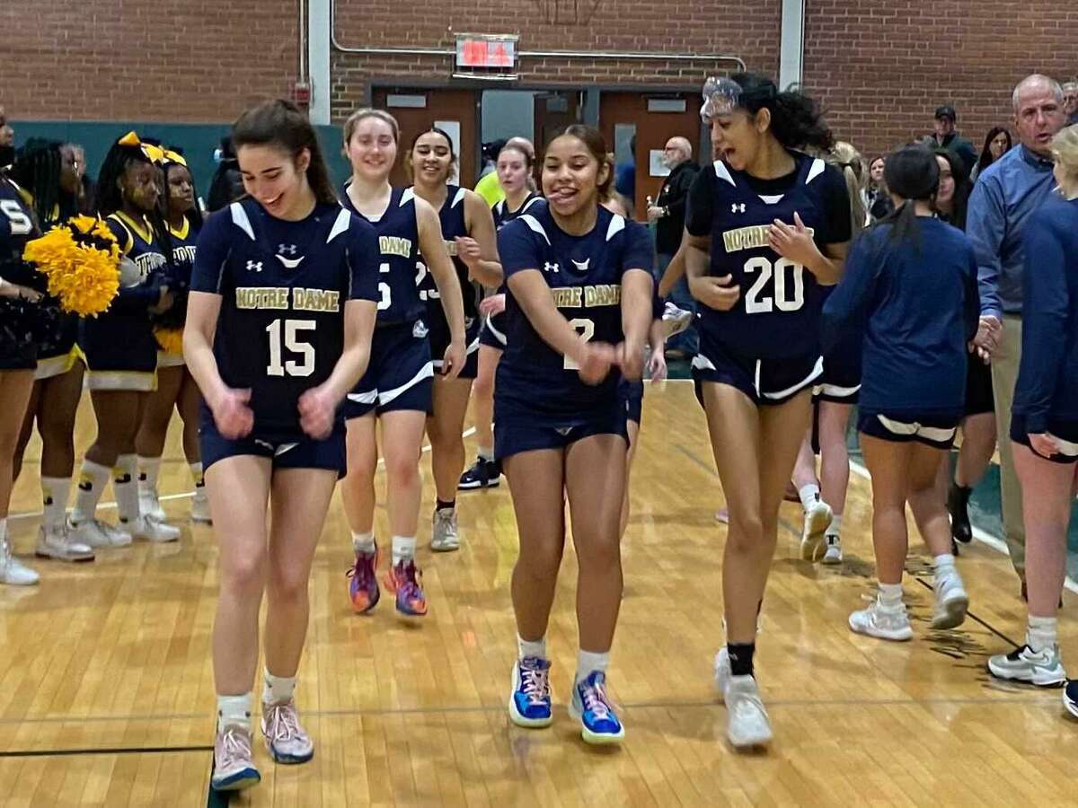 Members of the Notre Dame-Fairfield girls basketball team celebrate after defeating Simsbury 39-28 in the Class L tournament semifinal Monday at Maloney High School.