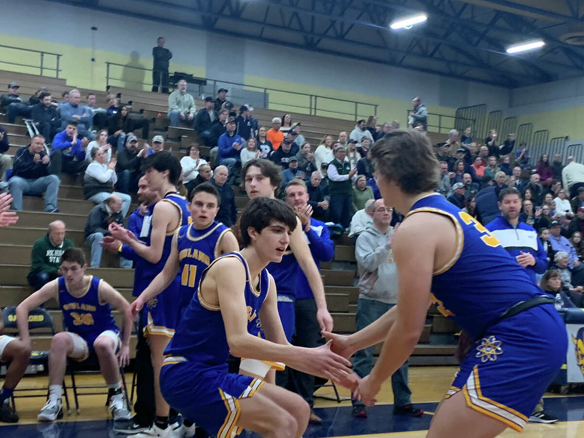 Midland High's Abe Haddad (left) shares a handshake with teammate Caden McPhillips during player introductions prior to a March 14, 2022 regional semifinal against Petoskey. Haddad had 14 points in the Chemics' loss to Traverse City Central on Wednesday.