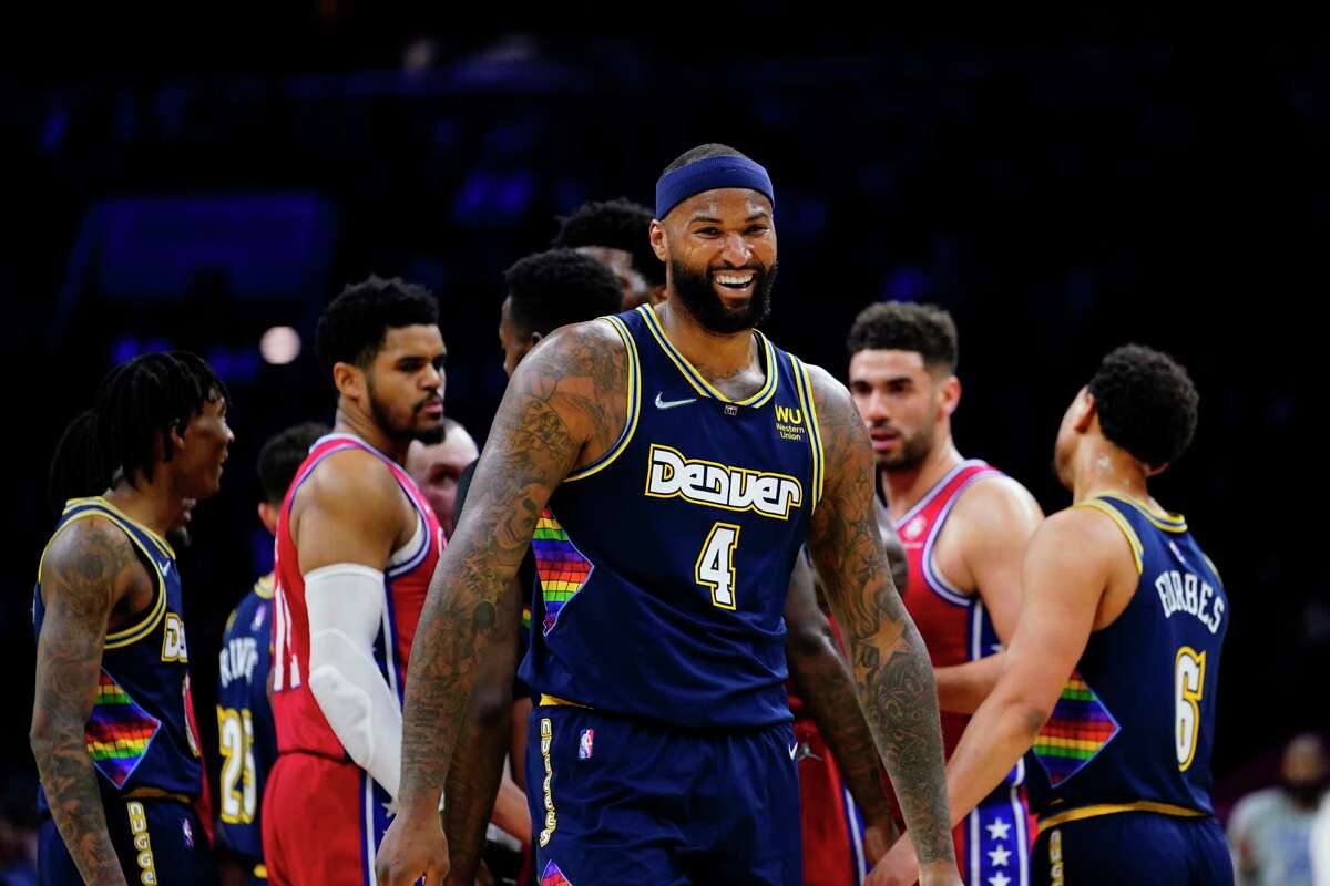 Denver Nuggets' DeMarcus Cousins laughs as he walks away from going chest-to-chest with James Harden before 76ers players quickly broke it up.