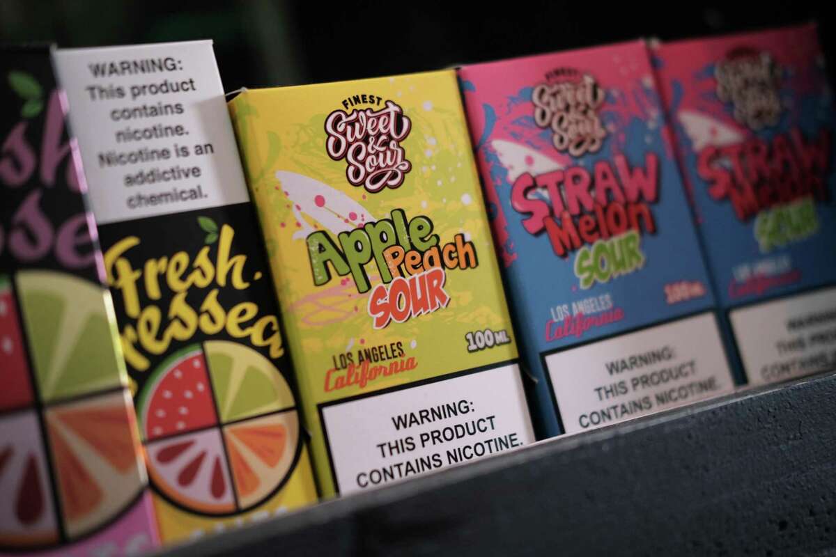 Vaping products, including flavored vape liquids and pods, are displayed at Gotham Vape in Queens, N.Y., in 2019.