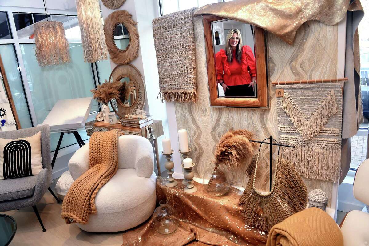Stephanie Herzog, owner of Bespoke Home, is reflected in a mirror in her store on Main Street in Branford on March 10.