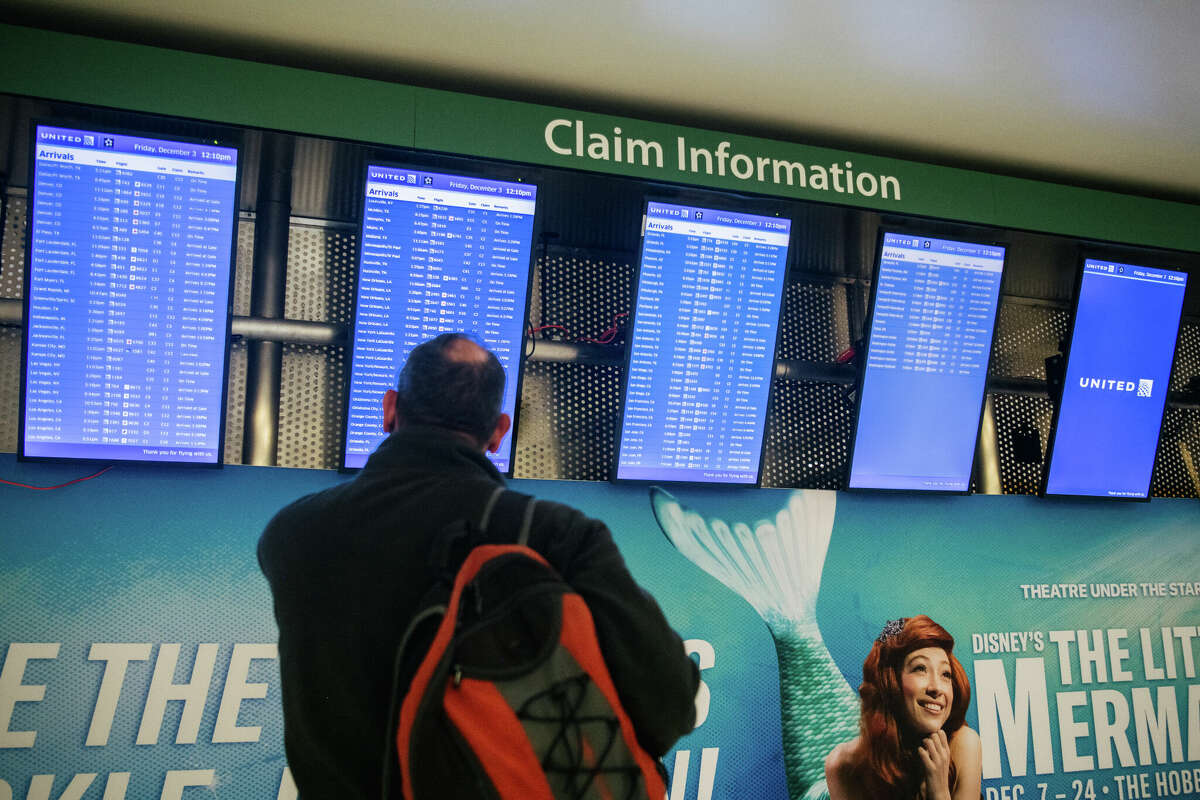 HOUSTON, TEXAS - DECEMBER 03: A traveller checks arrivals and departures flight information at George Bush Intercontinental Airport on December 03, 2021 in Houston, Texas. 