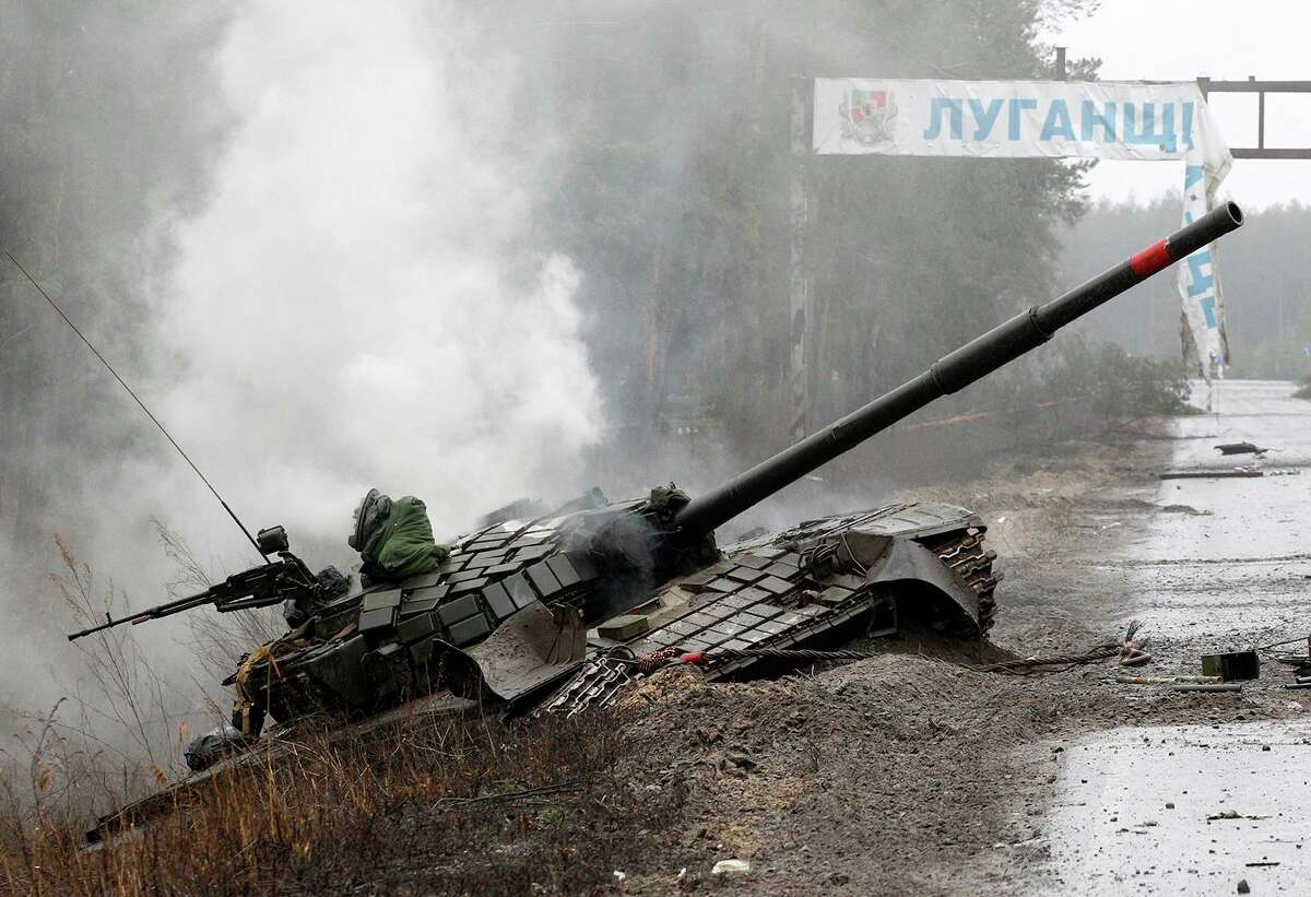 Smoke rises from a Russian tank destroyed by the Ukrainian forces on the side of a road in Lugansk region on Feb. 26, 2022. (Anatolii Stepanov/AFP via Getty Images/TNS)