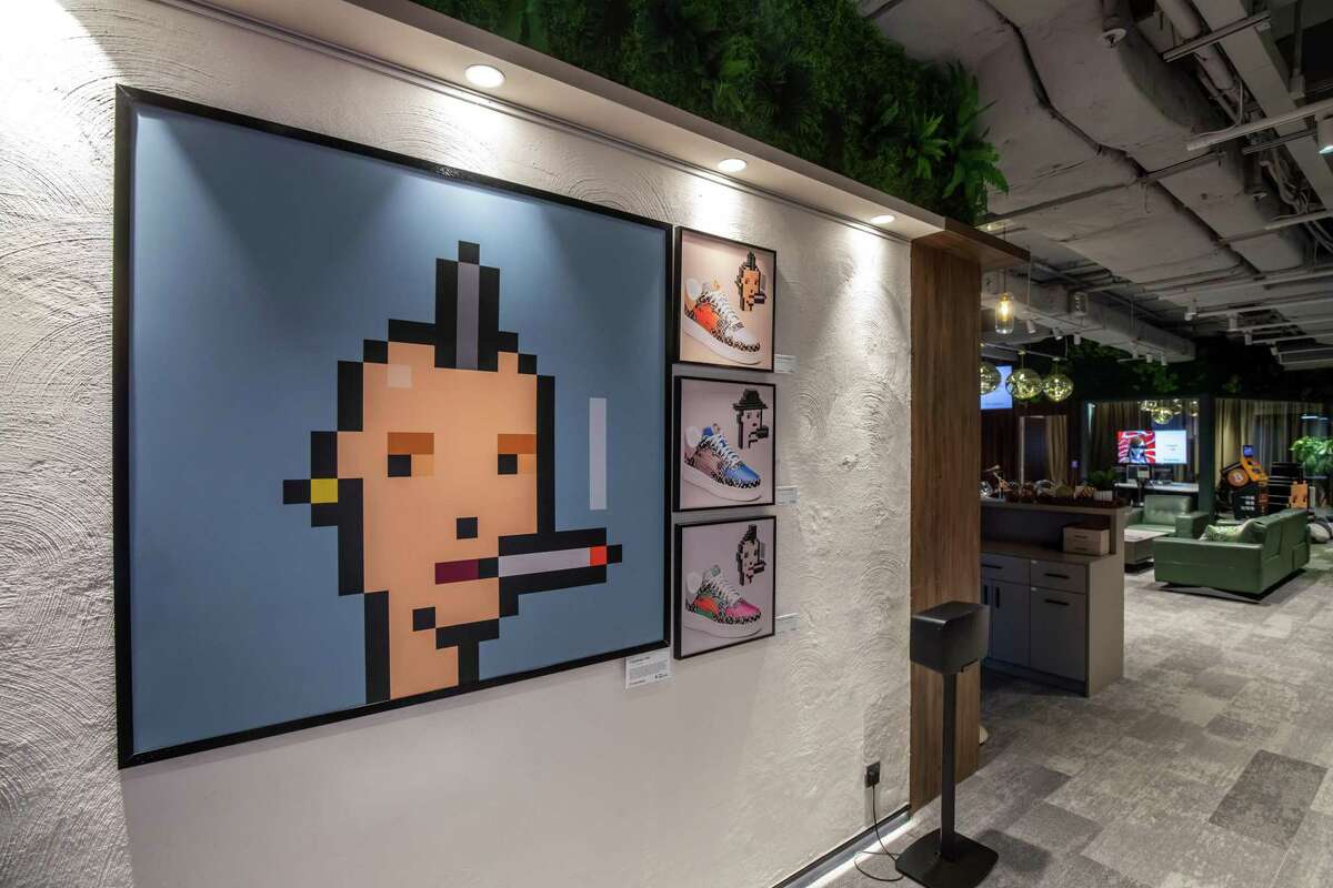 The physical artwork of "CryptoPunk #7810" created by Larva Labs, available for sale as an NFT, left, in the premier area at a CoinUnited cryptocurrency exchange in Hong Kong, China, on Friday, March 4, 2022.