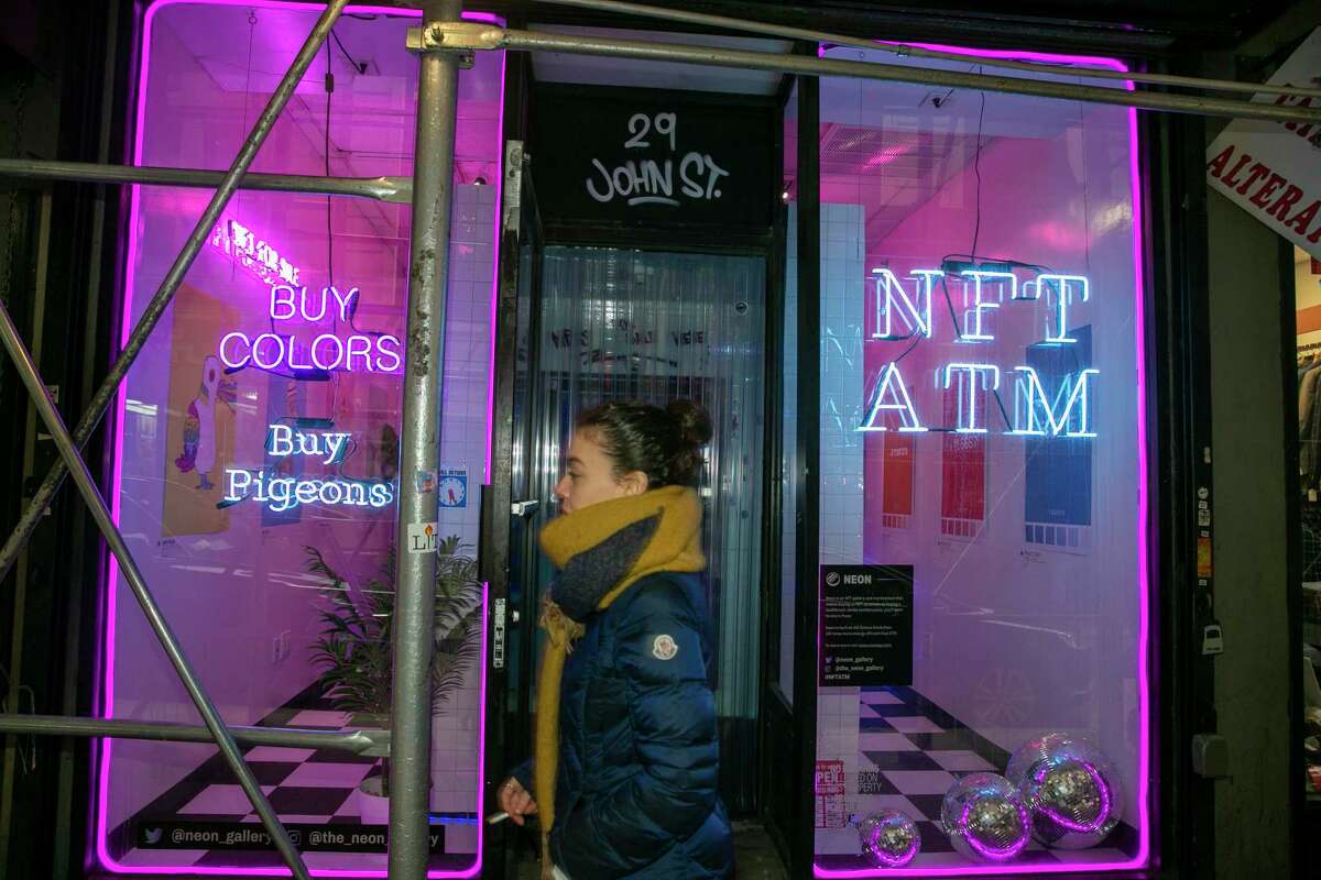 A person walks by a 24-hour non-fungible token vending machine near Wall Street in New York City on Thursday, Feb. 24, 2022. Customers receive a small box with a QR code to register a declaration of ownership of a virtual artwork on the Solana blockchain.