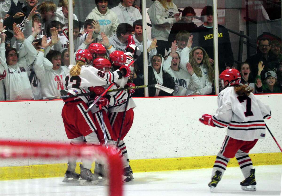 New Canaan celebrates after winning the CHSGHA girls ice hockey championship in triple overtime against Darien last Wednesday.