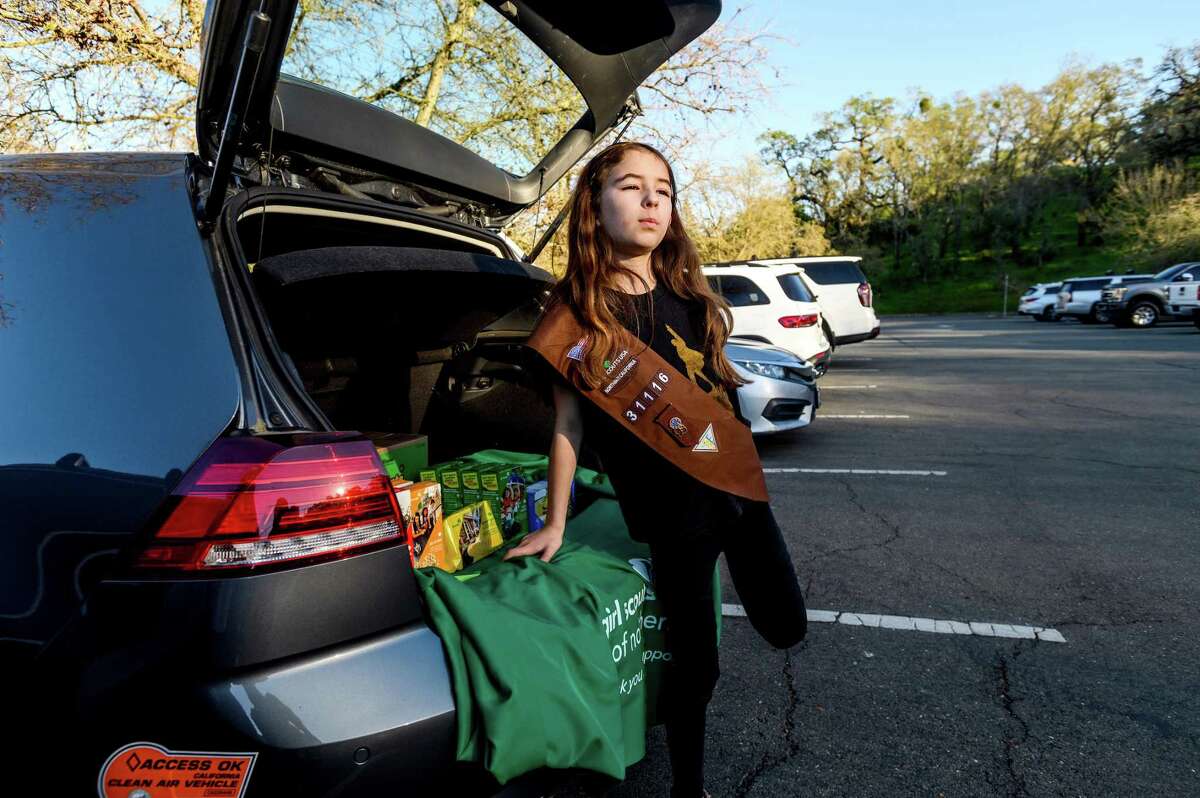Alex Johannesen, 8, tries to sell Girl Scout cookies from the trunk of her mom’s car in Lafayette. Although no one stopped to buy cookies, she was able to sell one box while wandering the stands at a Little League game.