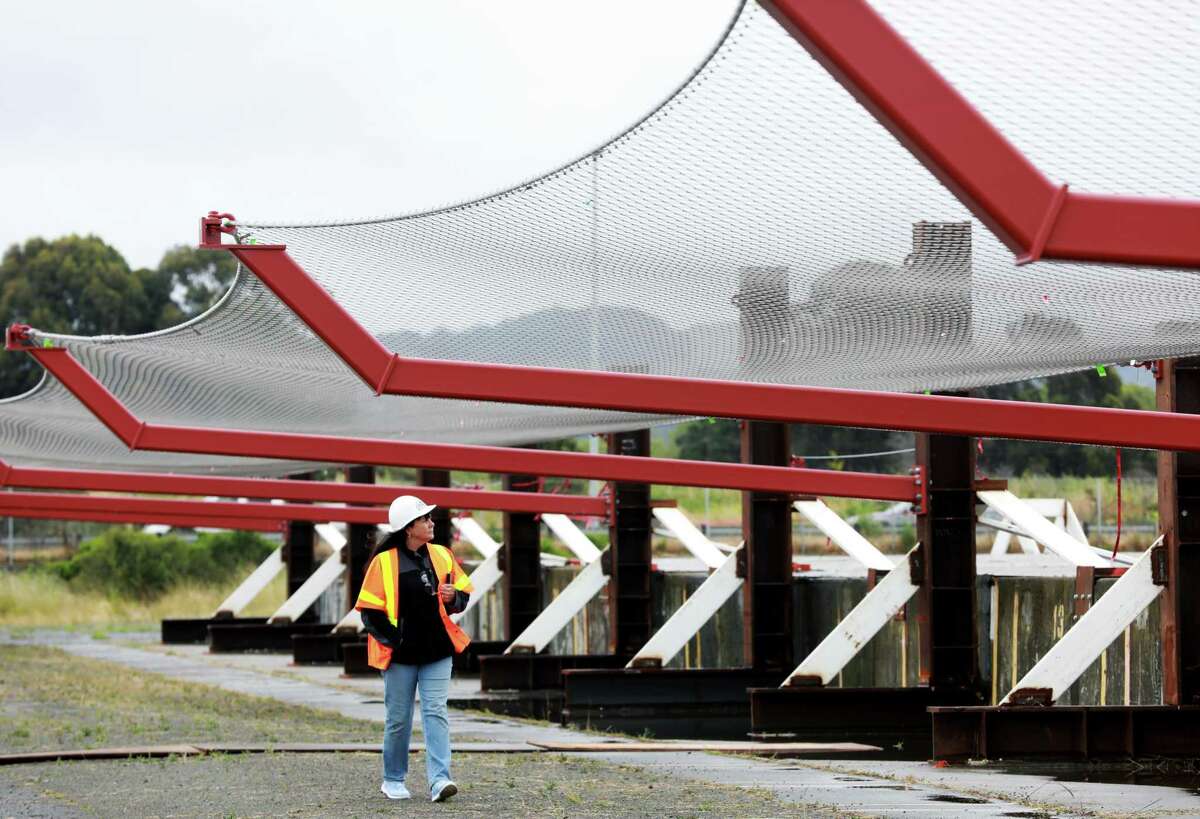 Dayna Whitmer walks beneath a suicide deterrent system net at the Richmond Yard in Richmond, Calif., on Thursday, May 16, 2019. Her son, Mattie, who at the age of 20, jumped from the Golden Gate Bridge on November 15, 2017. Advocates have long called for a suicide net beneath the bridge. After years of delays, the project appears back on track.