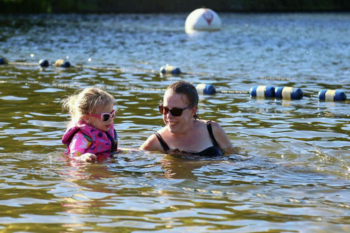 Joan Griffin of Fairfield brings her girl Emily in for a dip at Lake Mohegan on Sunday, Aug. 30, 2020, in Fairfield, Conn.