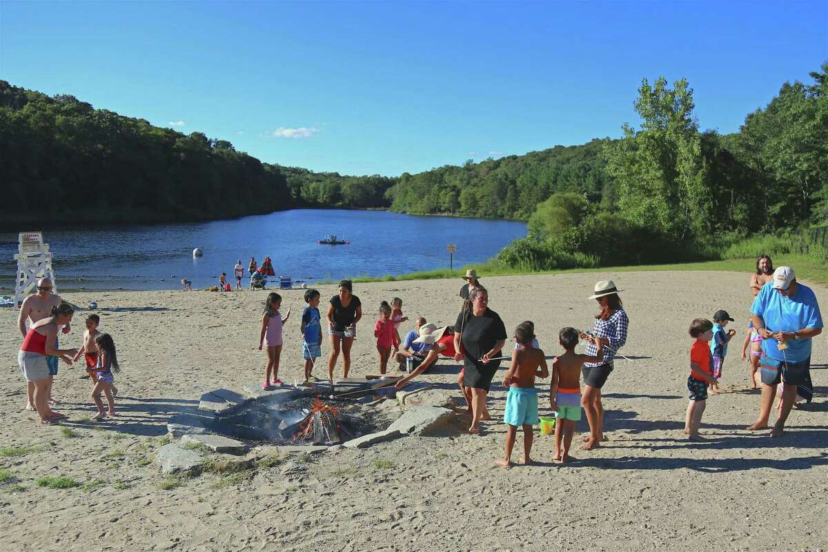Families hung around the fire pit roasting marshmallows at Lake Mohegan on Sunday, Aug. 30, 2020, in Fairfield, Conn.