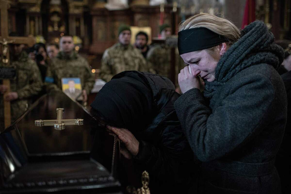 Relatives of Kyrylo Vyshyvany cry by his coffin during a funeral service Tuesday in Lviv, Ukraine. Vyshyvany, Oleh Yaschyshyn, Sergiy Melnyk and Rostyslav Romanchuk died Sunday in a Russian air strike on the nearby International Center for Peacekeeping and Security at the Yavoriv military complex.