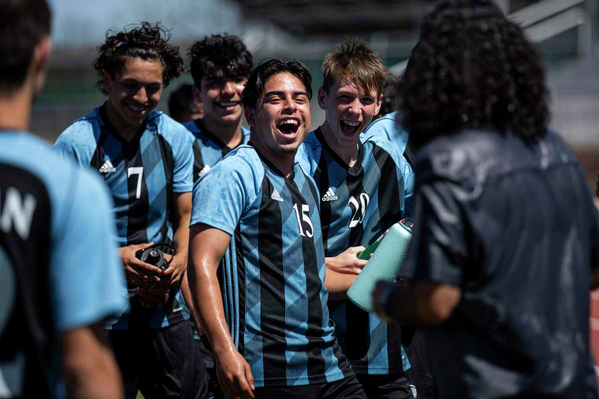 Harlan's Tomas Olivares (7), Caleb Castro (15), Greydyn Richards (20) and the rest of the Hawks celebrate their 6-0 win over the Warren Warriors at Gustafson Stadium, Tuesday, March 15, 2022, in San Antonio, Texas. The team soaked their head coach Bert Atilano, right, in water during a celebratory huddle.