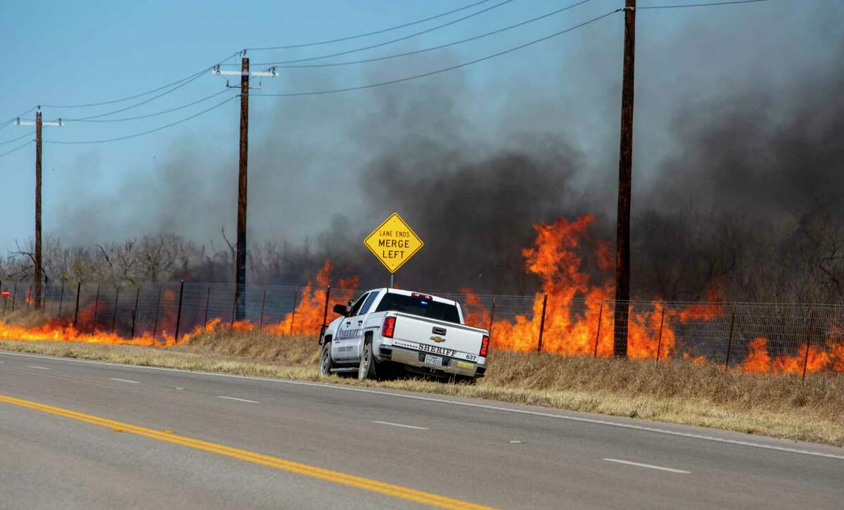 A sheriff?•s deputy monitors a wildfire Tuesday, Mar. 15, 2022 south of Jourdanton in Atascosa County. In addition to area fire departments on the ground, the Texas Forest Service used the one helicopter and two large tankers to fight the fire.