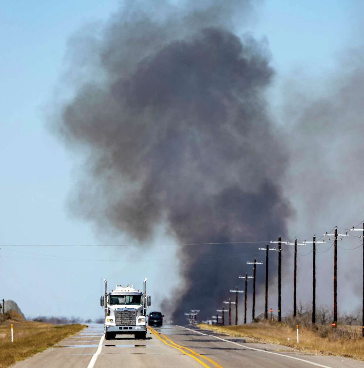 Smoke from a wildfire rises Tuesday, March 15, 2022 along Highway 16 south of Jourdanton in Atascosa County. In addition to area fire departments on the ground, the Texas Forest Service used the one helicopter and two large tankers to fight the fire.
