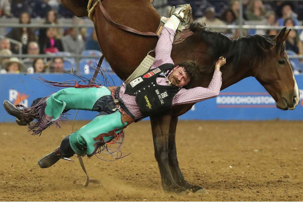 Wyatt Denny gets his hand hung up as he is bucked off by Utopia in the bareback riding competition during Super Series V, round 3, at RodeoHouston Tuesday, March 15, 2022 in Houston.