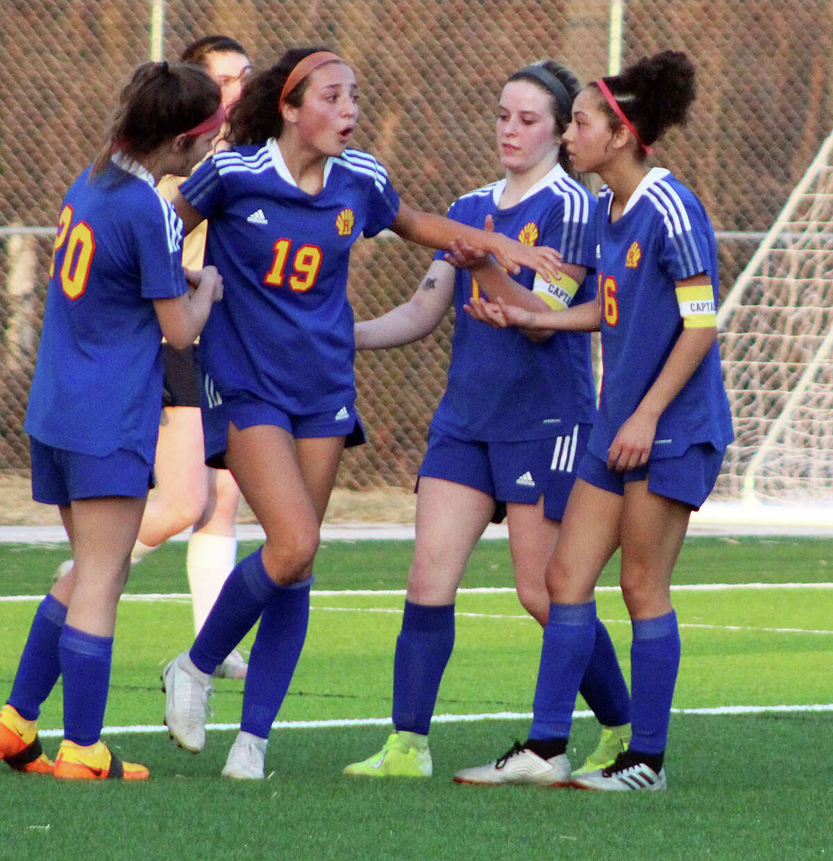 Roxana's Kendall Kamp (19) is surrounded by teammates after she scored a second-half goal against Father McGivney High Tuesday in a Metro Cup game at Norman Lewis Field.