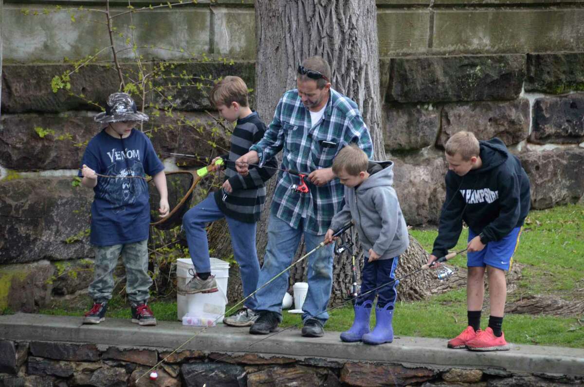 Young anglers surround Kurt Schutz on May 4 at the annual Milford Striped Bass Club’s annual Children’s Trout Derby in Milford. The children with Schutz include his son, Lance, and a group of others who were trying to recapture a fish that has slipped back into the water.