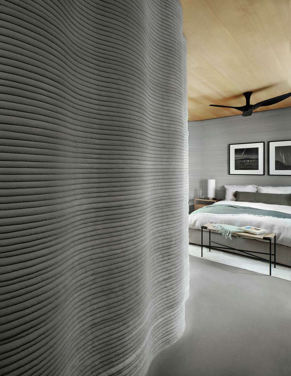 The owner’s suite is designed so the 3D-printed wall starts as a headboard but continues to make up part of the bedroom wall.