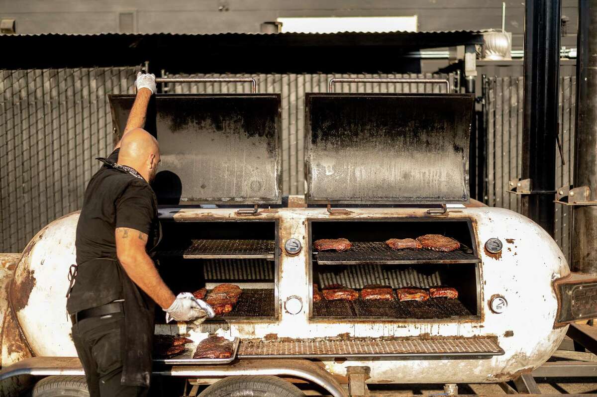 Matt Johnston checks meat in a smoker at Horn Barbecue in Oakland. The restaurant is up for the 2022 James Beard Foundation’s best new restaurant award.
