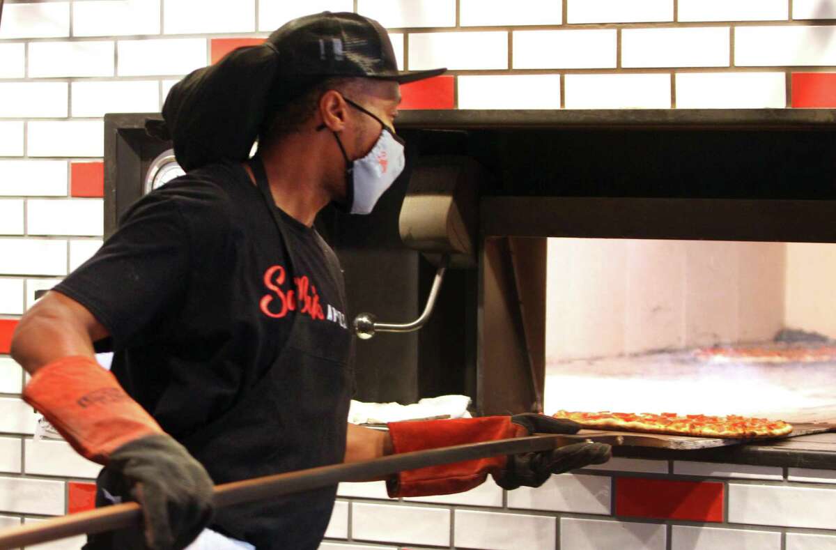 Jeffery Newton bakes a pizza during the grand opening of Sally's Apizza on Summer Street in Stamford, Conn., on Thursday October 7, 2021. This is the new outpost of the beloved New Haven pizza restaurant.