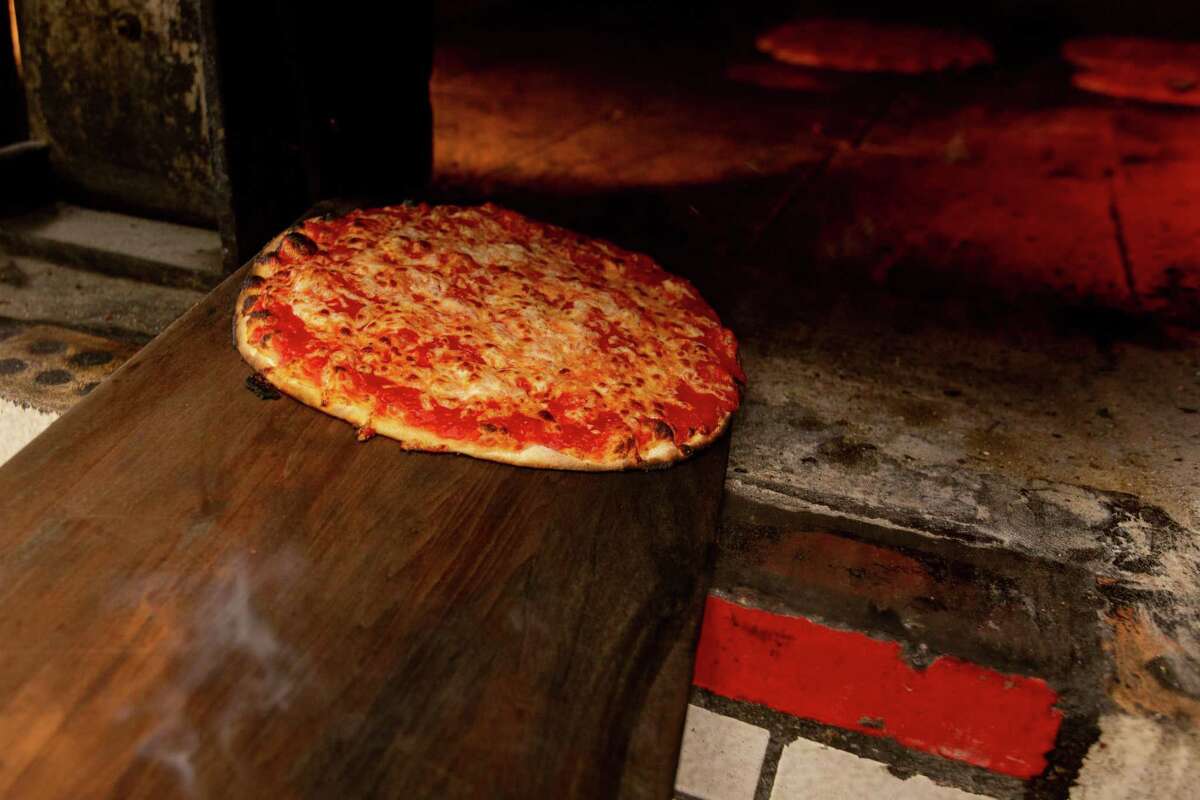 Hot pizza being pulled out of the oven at Sally's Apizza in New Haven on April 23, 2021.