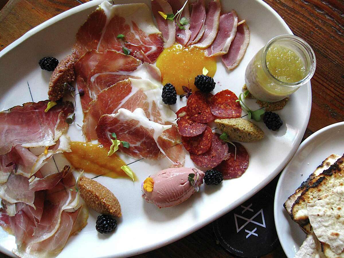 Charcuterie plate with nine-month speck, 12-month culatello, duck ham, apple-jalapeño pork rillette, orange and pecan salami, and chicken liver mousse with beer crackers, jams and mustards from Cured