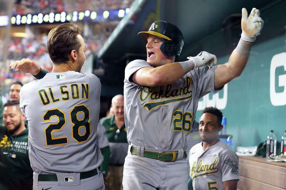 ARLINGTON, TEXAS - AUGUST 14: Matt Olson #28 celebrates with Matt Chapman #26 of the Oakland Athletics after Chapman's second home run against the Texas Rangers in the seventh inning at Globe Life Field on August 14, 2021 in Arlington, Texas. (Photo by Richard Rodriguez/Getty Images)