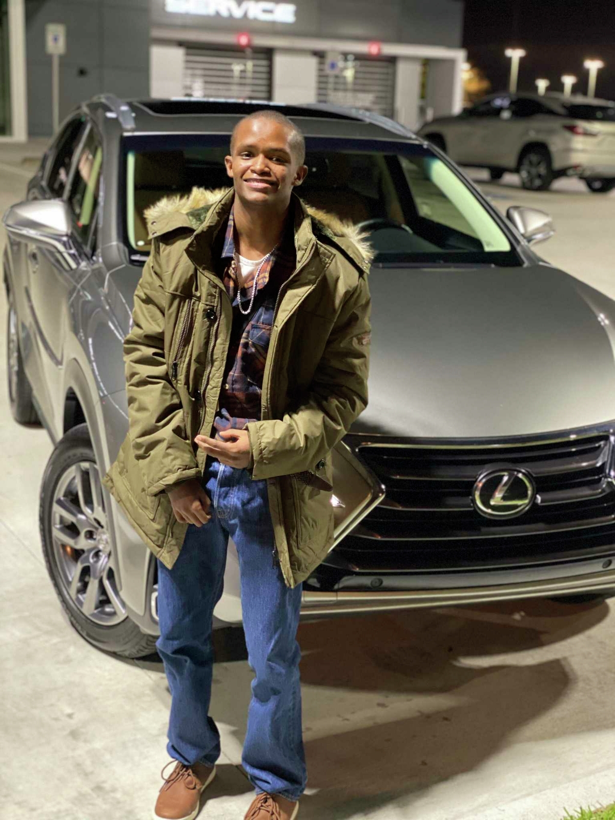 Fred Harris, who had an IQ of 62, stands in front of a Lexus SUV. Fred, who was 19 and had special needs, was killed in an incident with an inmate in the Harris County Jail in 2021.