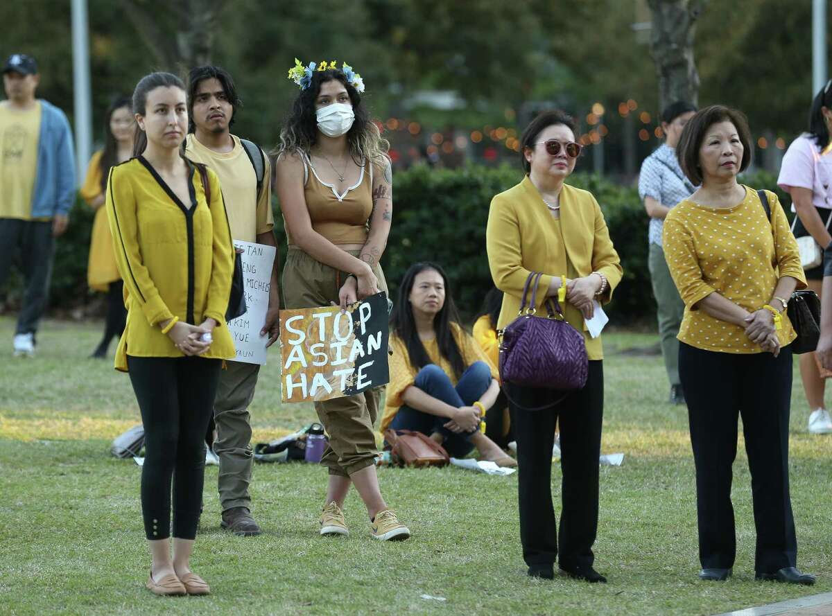 People listen to speakers during a rally to commemorate the one-year anniversary of the Atlanta spa mass shootings where six Asian and Asian American women were killed, Discovery Green on Wednesday, March 16, 2022, in Houston.