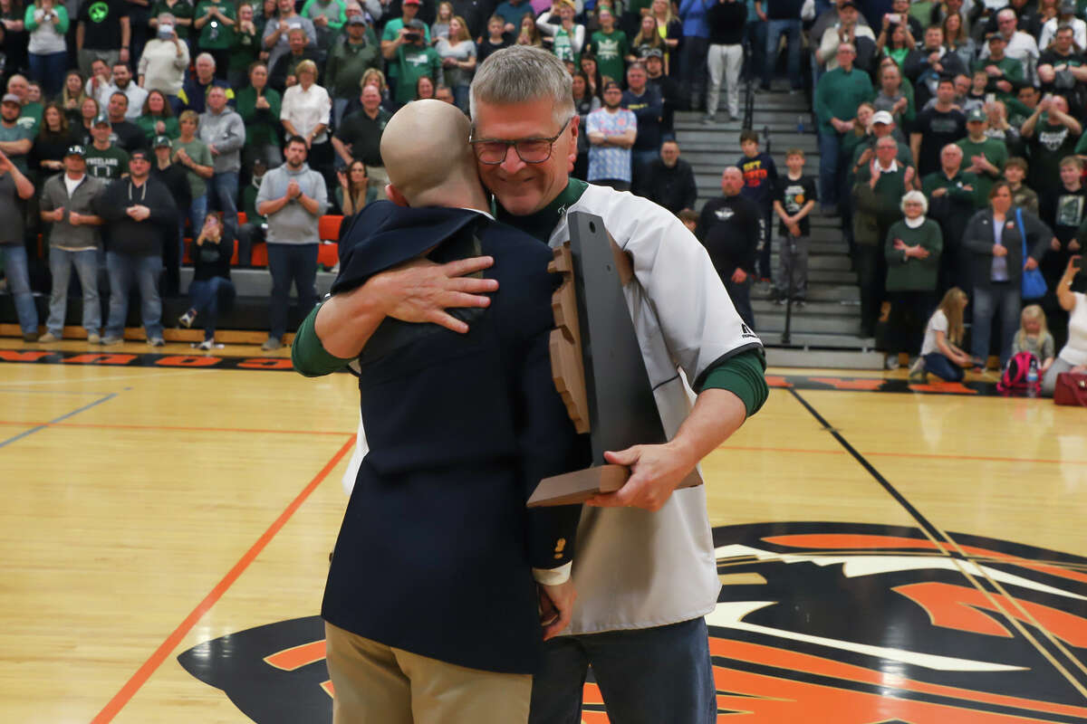 Freeland head coach John Fattal receives trophy after the Falcons' regional final victory over Flint Hamady Tuesday, March 15, 2022 at Alma High School.