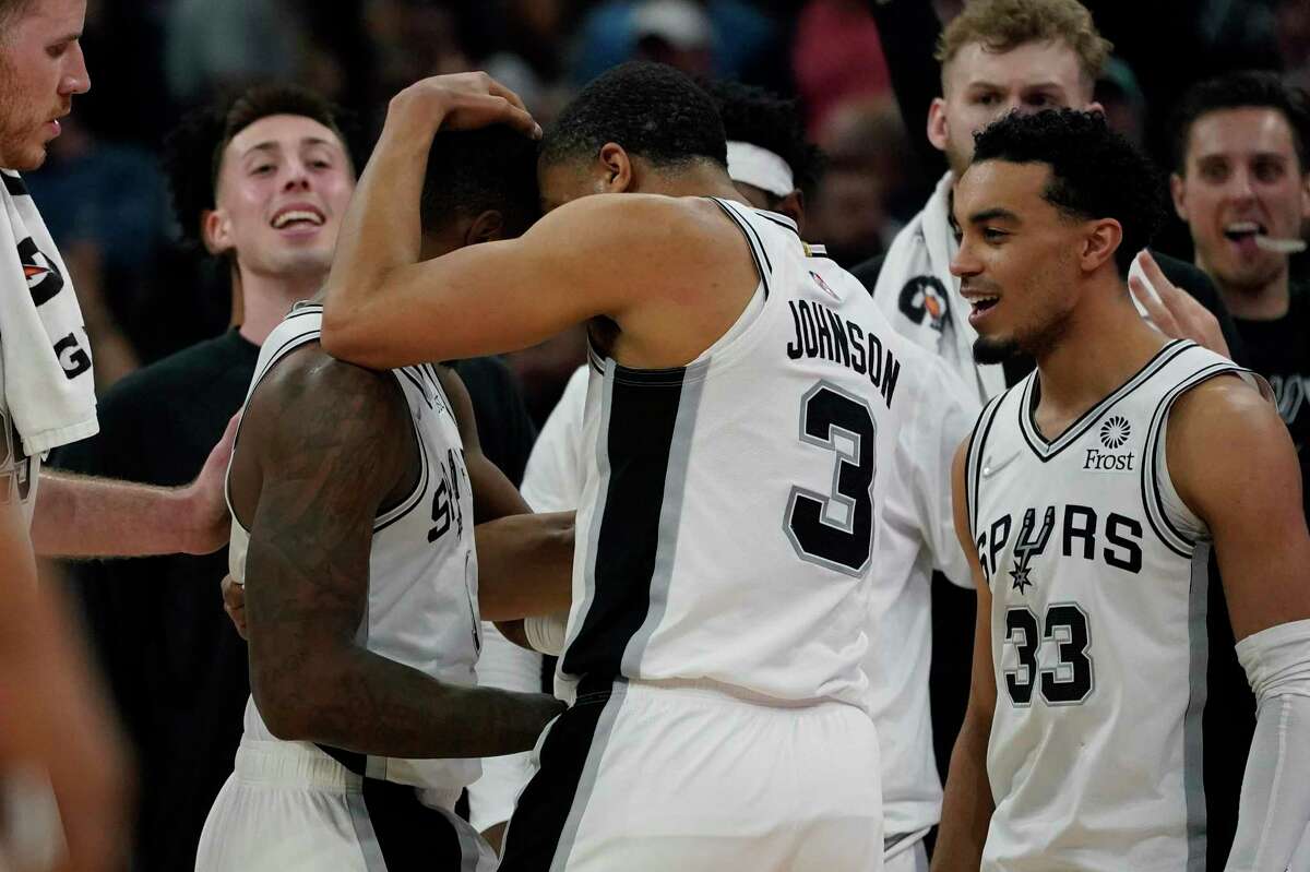 San Antonio Spurs guard Lonnie Walker IV, left, celebrates with teammates after he shot the winning basket against the Oklahoma City Thunder during the final seconds of the second half of an NBA basketball game, Wednesday, March 16, 2022, in San Antonio. (AP Photo/Eric Gay)