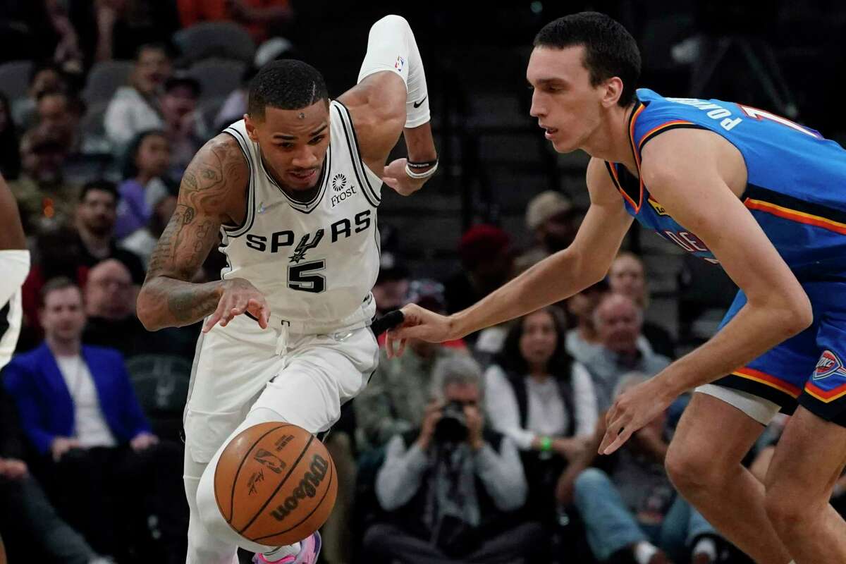 San Antonio Spurs guard Dejounte Murray (5) races up court past Oklahoma City Thunder center Aleksej Pokusevski (17) during the second half of an NBA basketball game, Wednesday, March 16, 2022, in San Antonio. (AP Photo/Eric Gay)