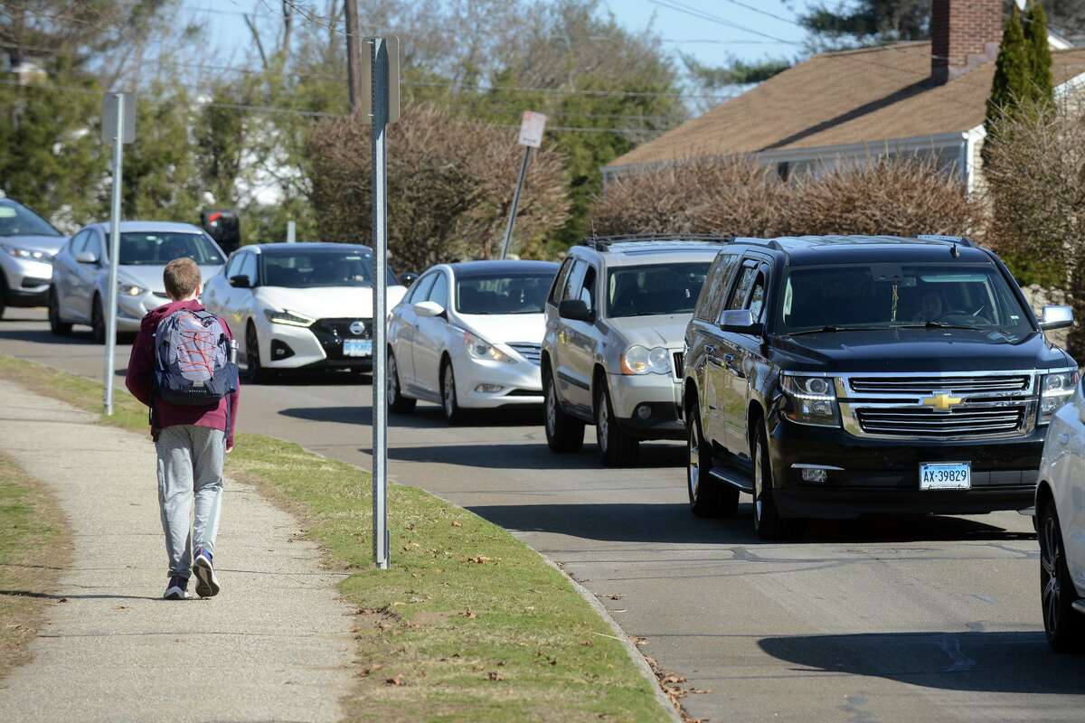 Cars wait in line along King St. as school lets out at Naramake Elementary School, in Norwalk, Conn. March 16, 2022.